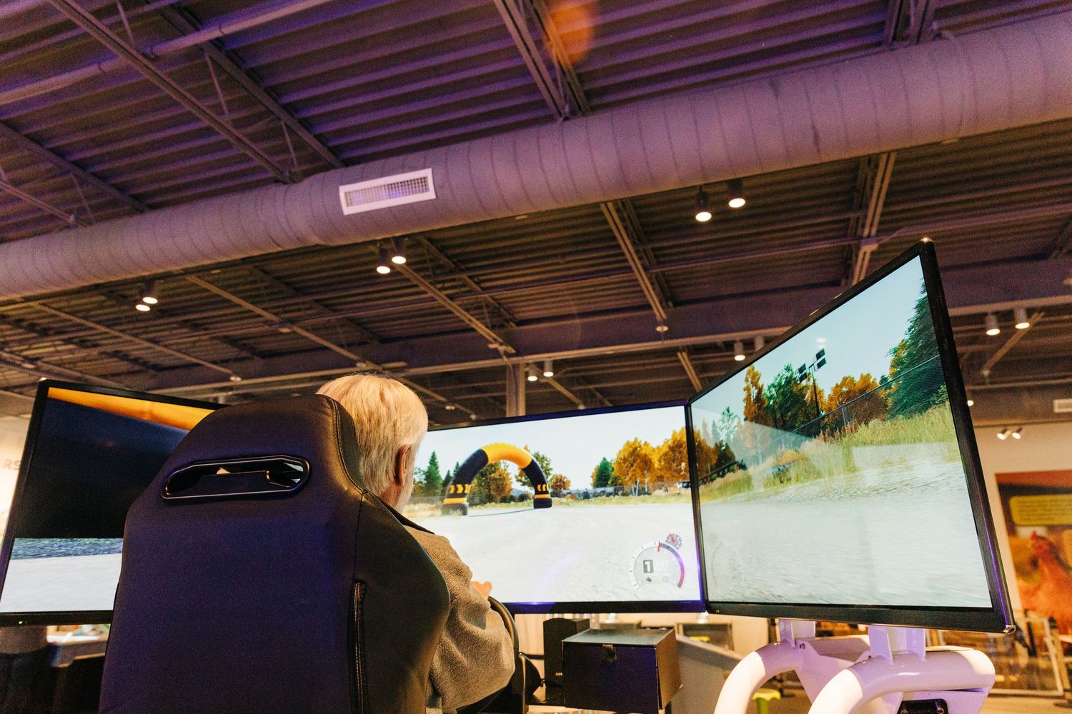 man playing race care VR game at Monroe Science Center