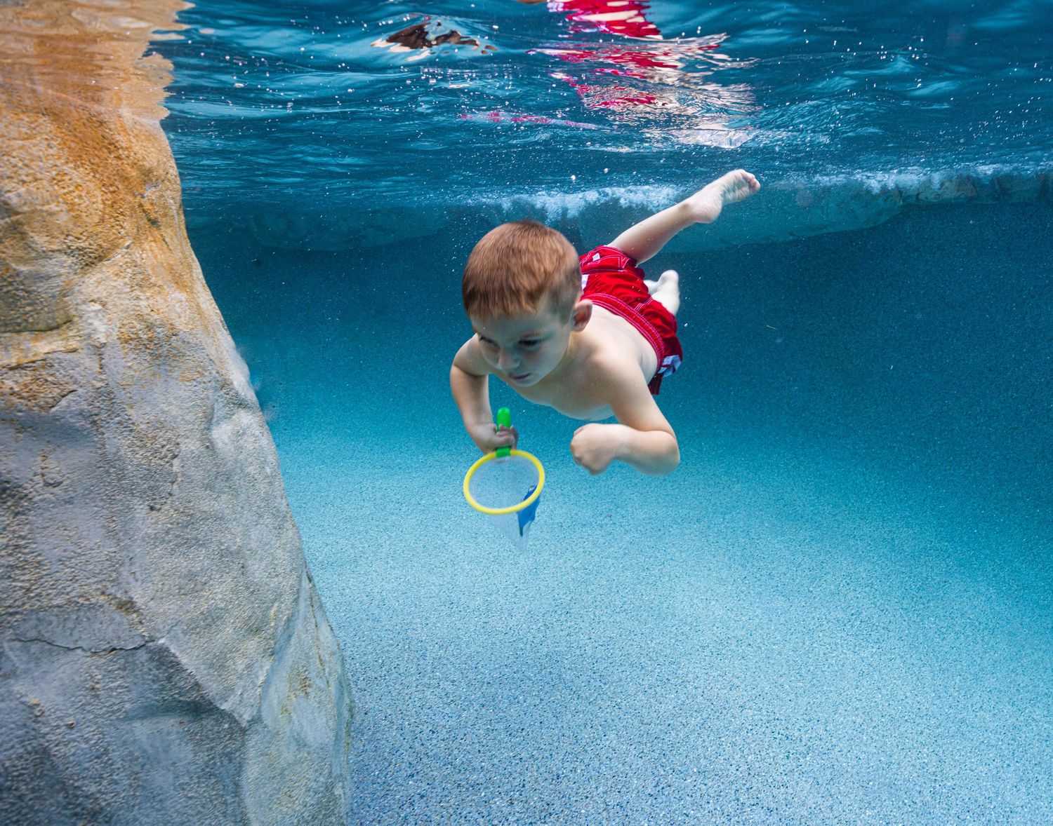 Little boy swimming underwater photo