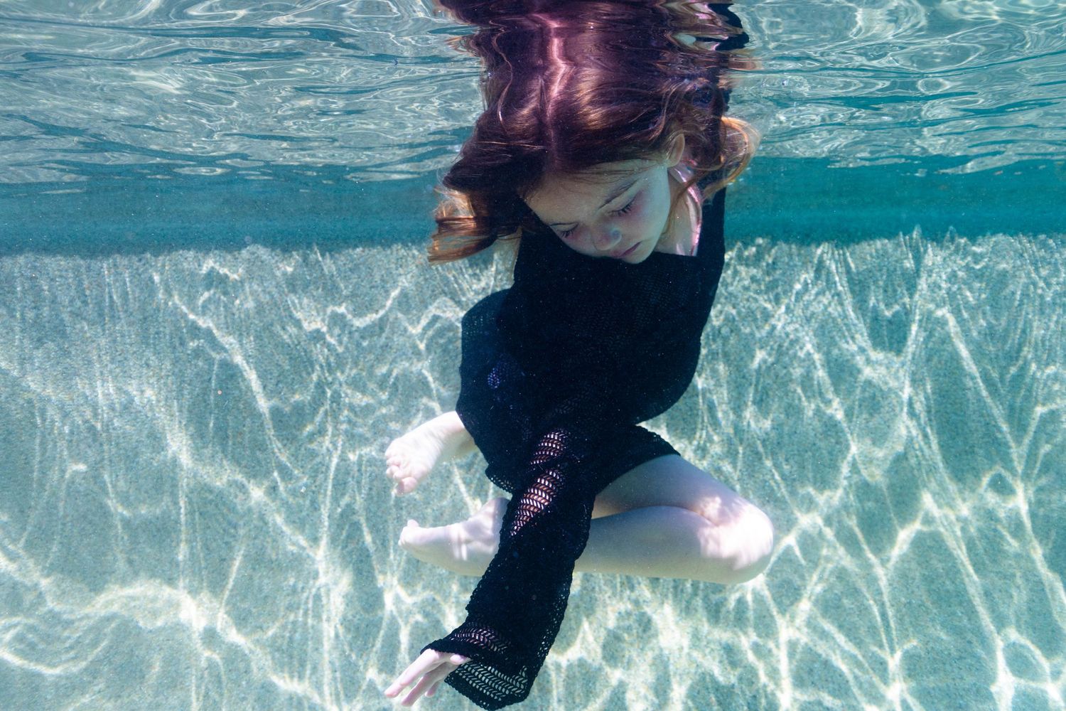 Little girl swimming underwater photo