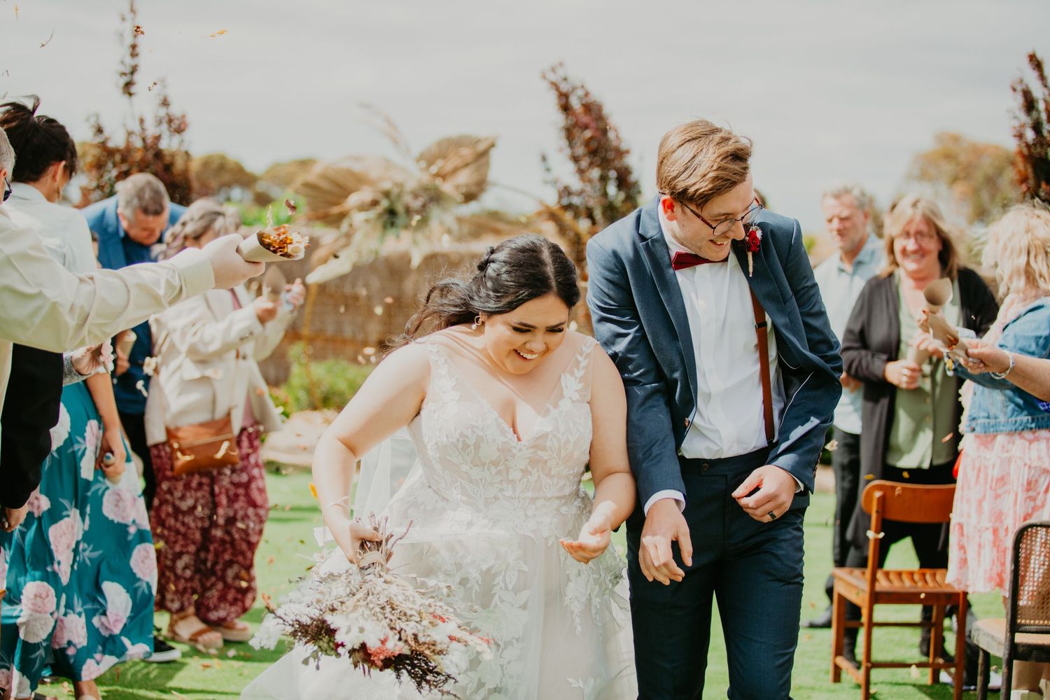 bride and groom at Redwing Farm with family throwing petals at them
