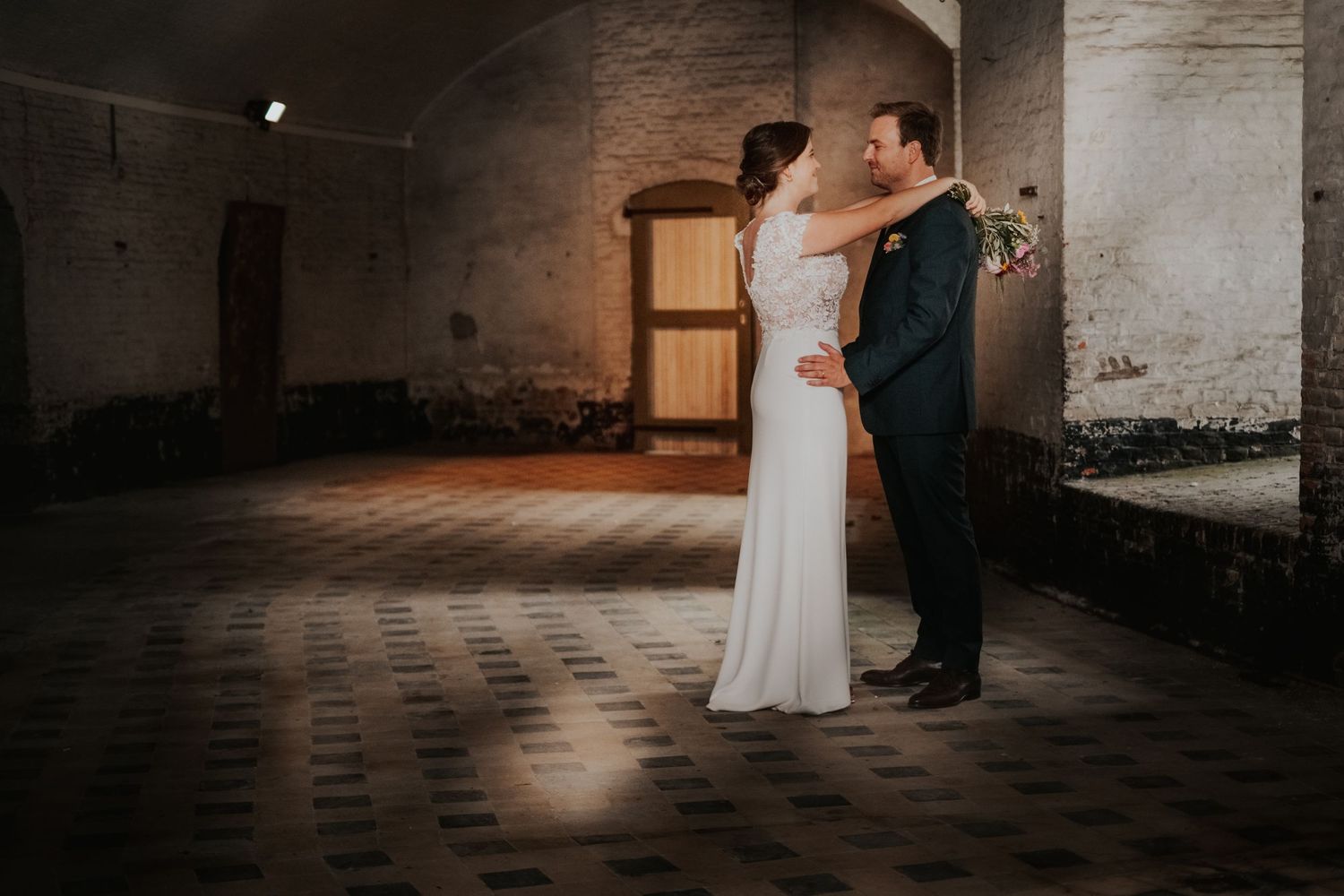 koppelshoot tijdens huwelijk. Koppel kijkt verliefd naar elkaar en omarmd zich.