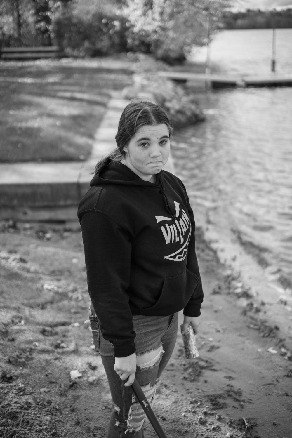 Person in a black hoodie exploring a waterfront path.
