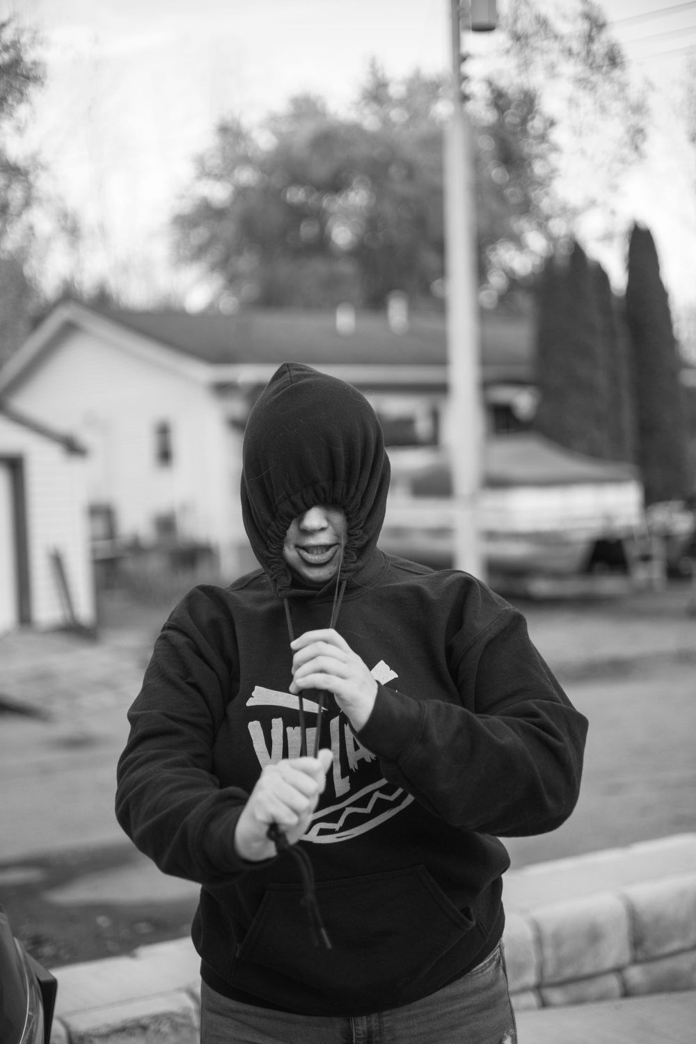 Person in dark hoodie enjoying snacks outdoors.