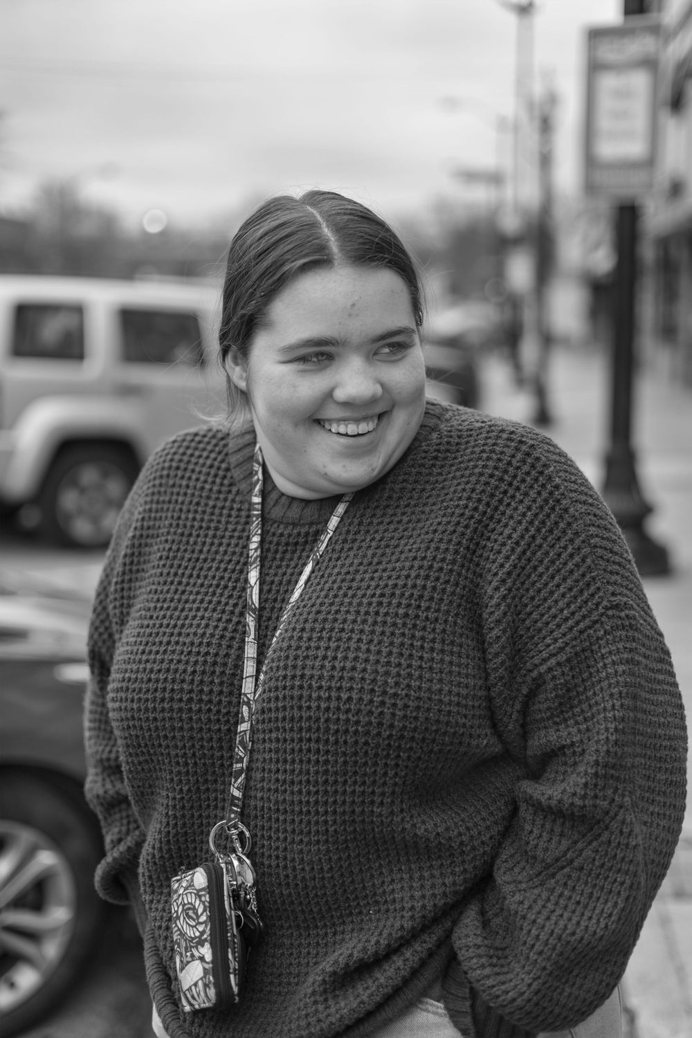 Person wearing a knit sweater smiling outdoors in winter.