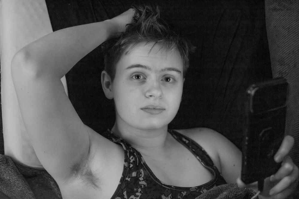 Black and white selfie of a person wearing a tank top.