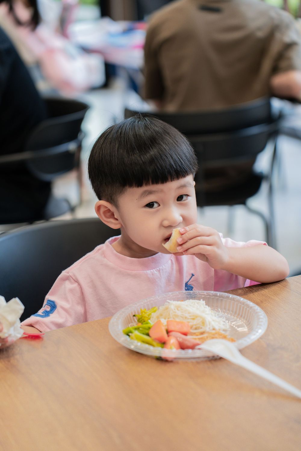 A young child eating at a table during a birthday celebration.