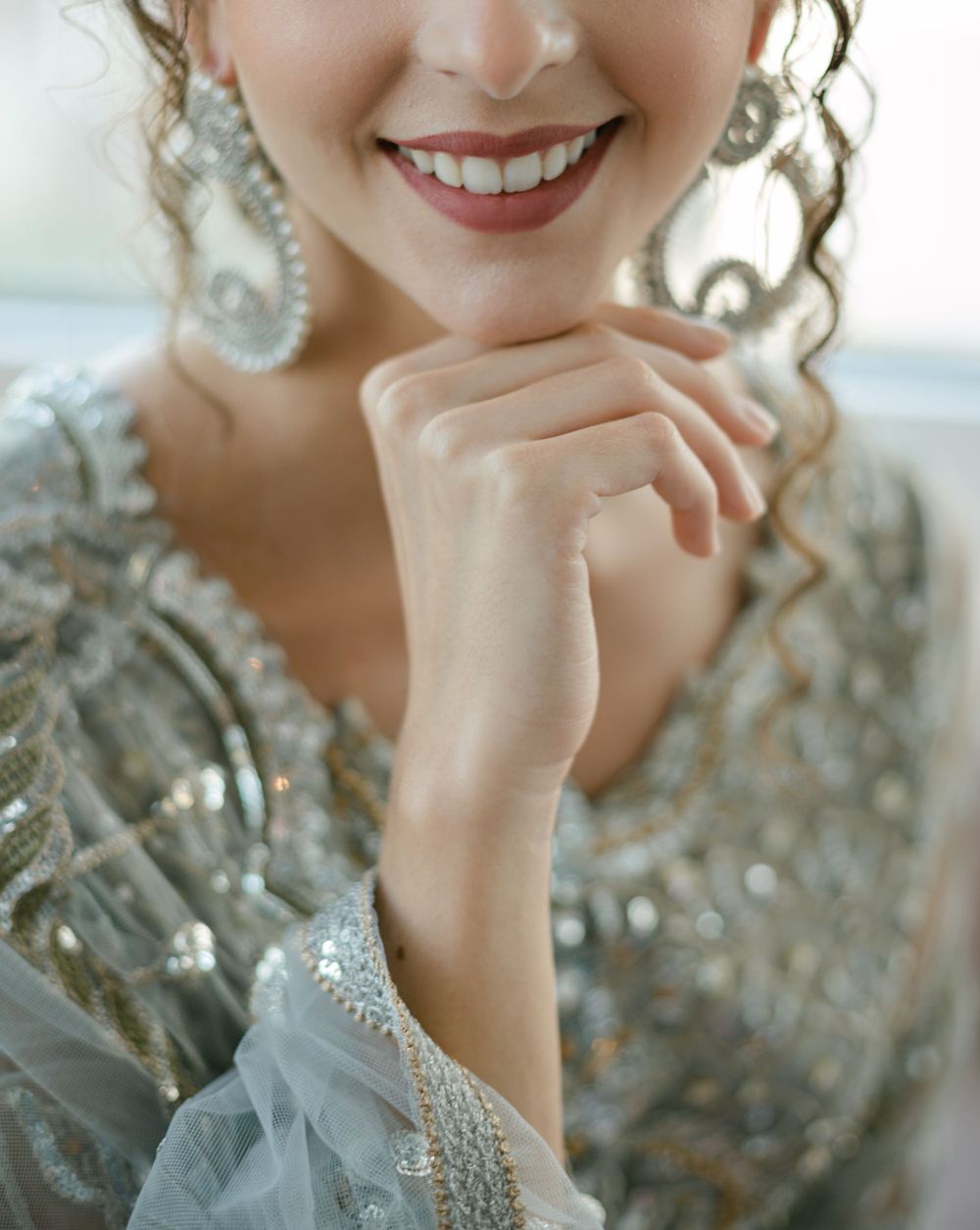 A detailed shot of sparkling silver beadwork and pearl accessories on elegant bridal attire.