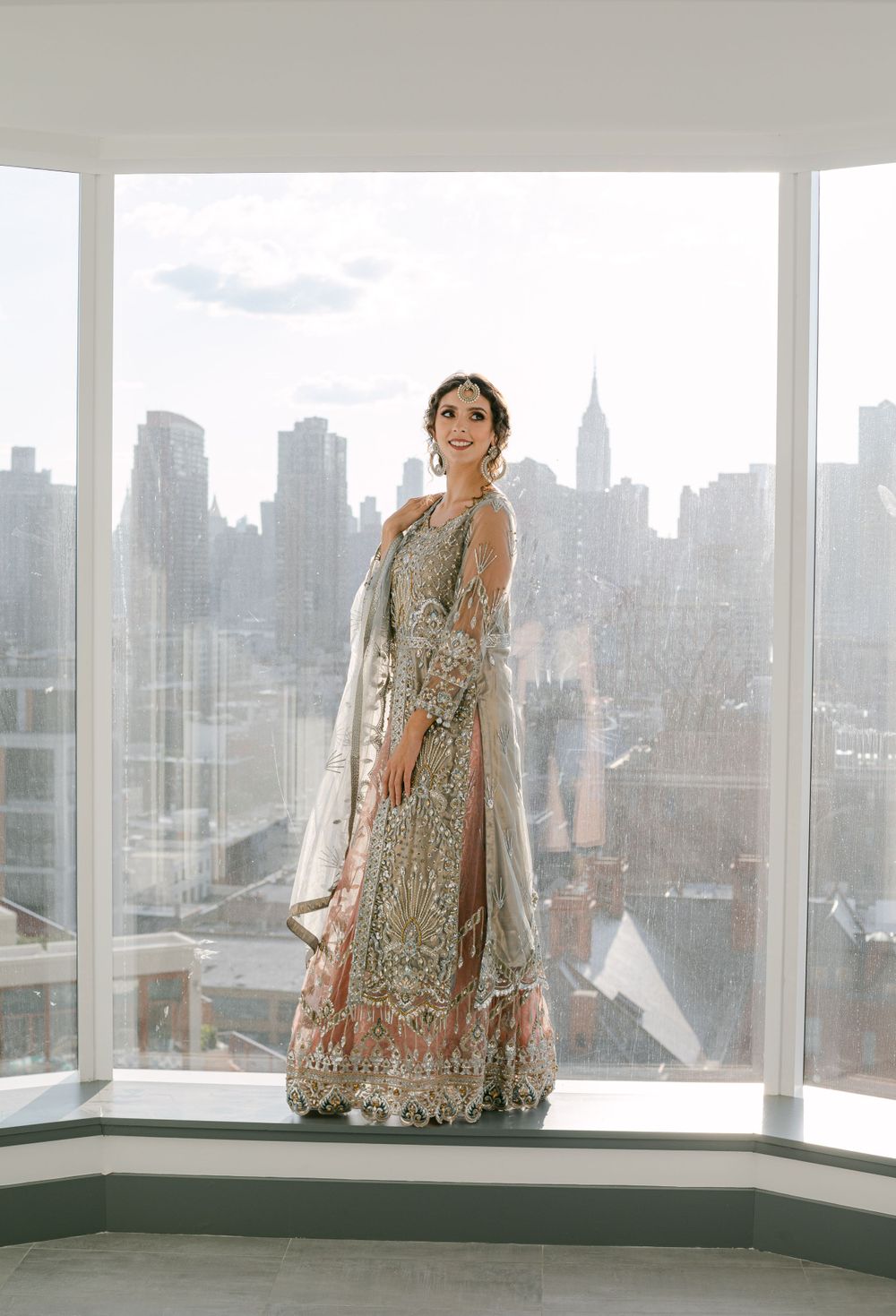 Elegant formal wear against New York City skyline backdrop in a high-rise apartment.