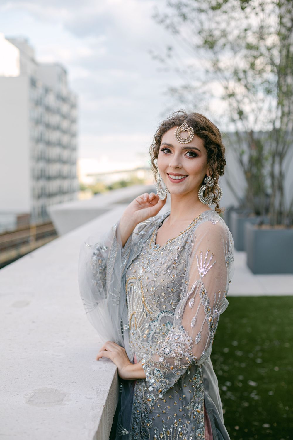 Detailed silver embellished dress captured in outdoor rooftop setting.
