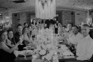 Wedding guests dining in a rustic brick-walled venue during an evening celebration.