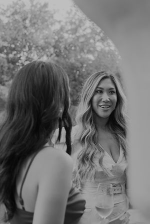 Black and white photo of two women having a conversation outdoors.