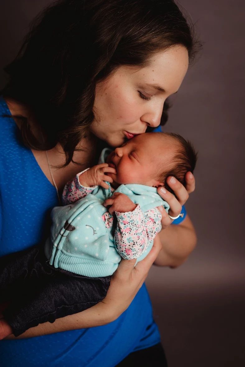 Tender moment between parent and baby in soft lighting.