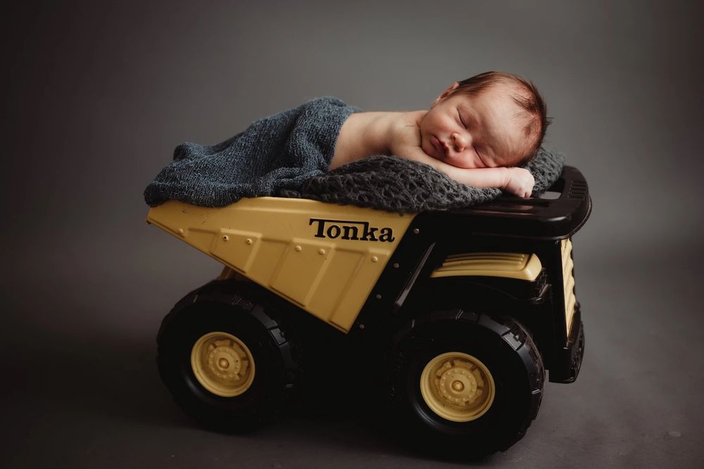 Creative newborn photo with vintage Tonka truck prop.