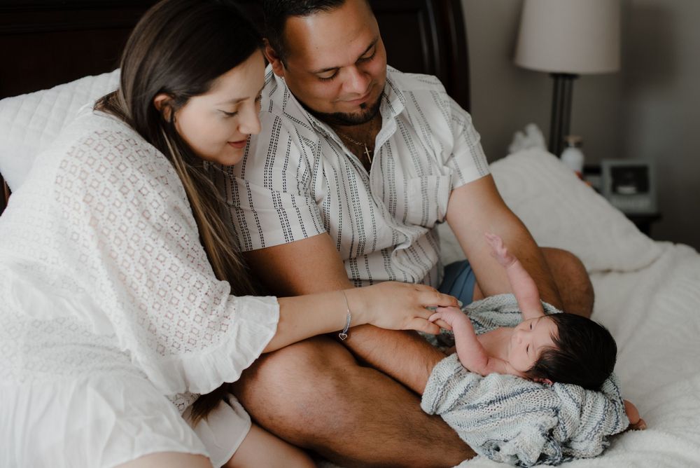 A tender family moment captured in a nursery with soft natural lighting.