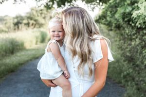 Mother and child sharing a joyful moment together on a sunny path.