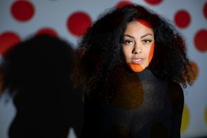 Fashion style portrait of young woman with projection of colours over face.