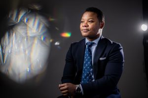 Dramatic portrait of a businessman in suit being backlit.