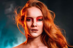 colour gel portrait of red haired woman in red makeup.