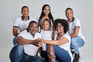 Family portrait on white background of parents posing with children.