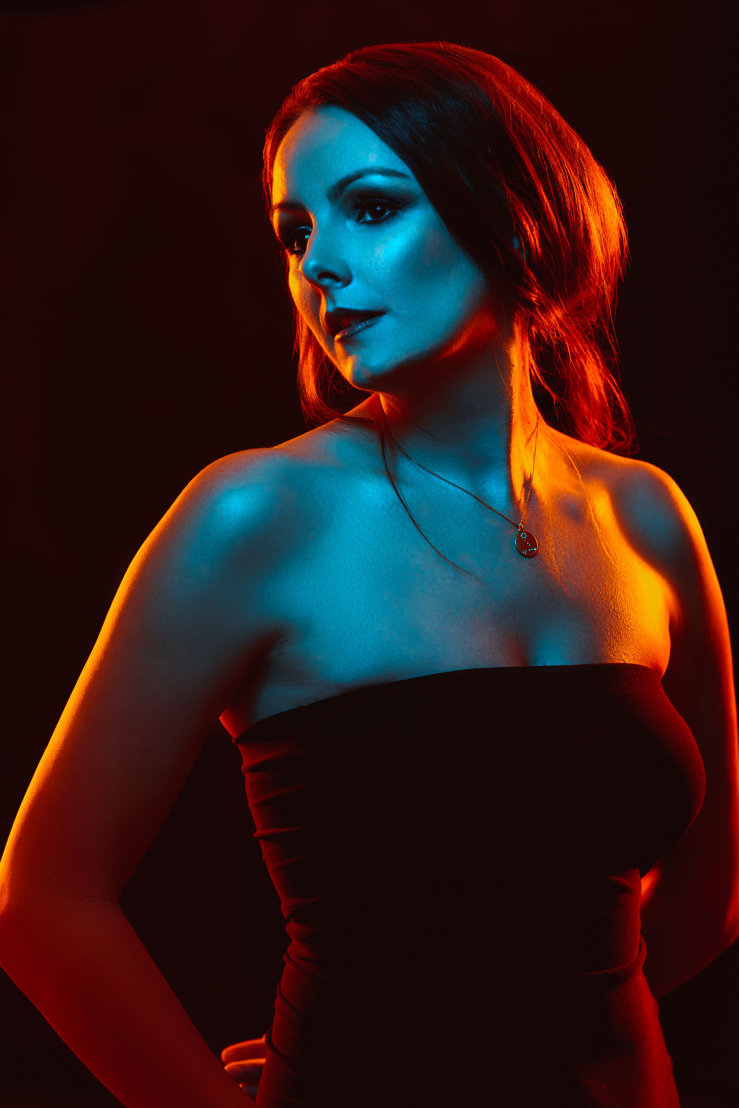 Colour gel fashion style portrait of young woman in orange and blue.