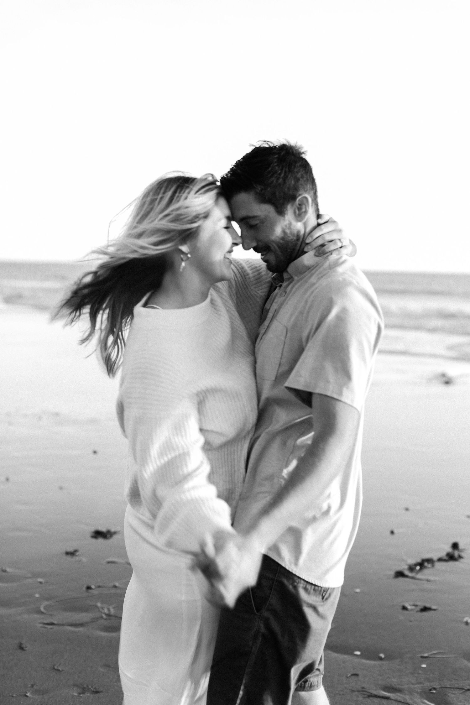 black and white image of couple on the beach by Leah Anne Kopp Photography