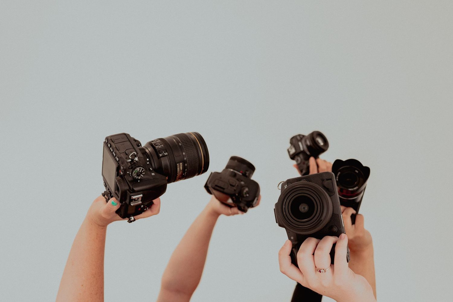 Women holding cameras in the air
