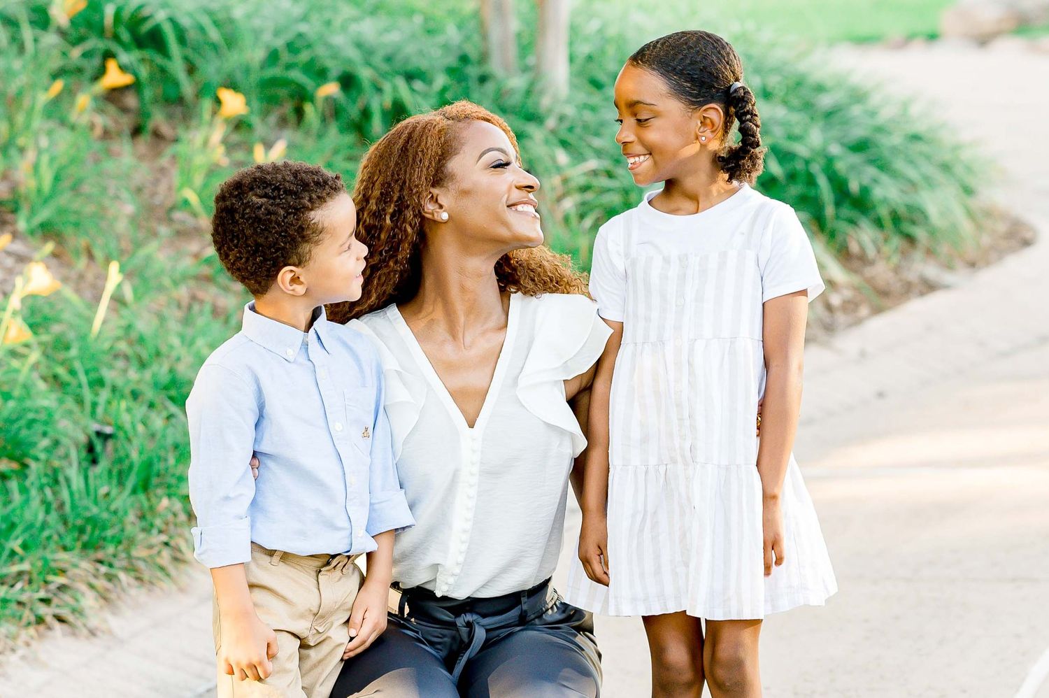 Family walking and laughing together on outdoor nature path.