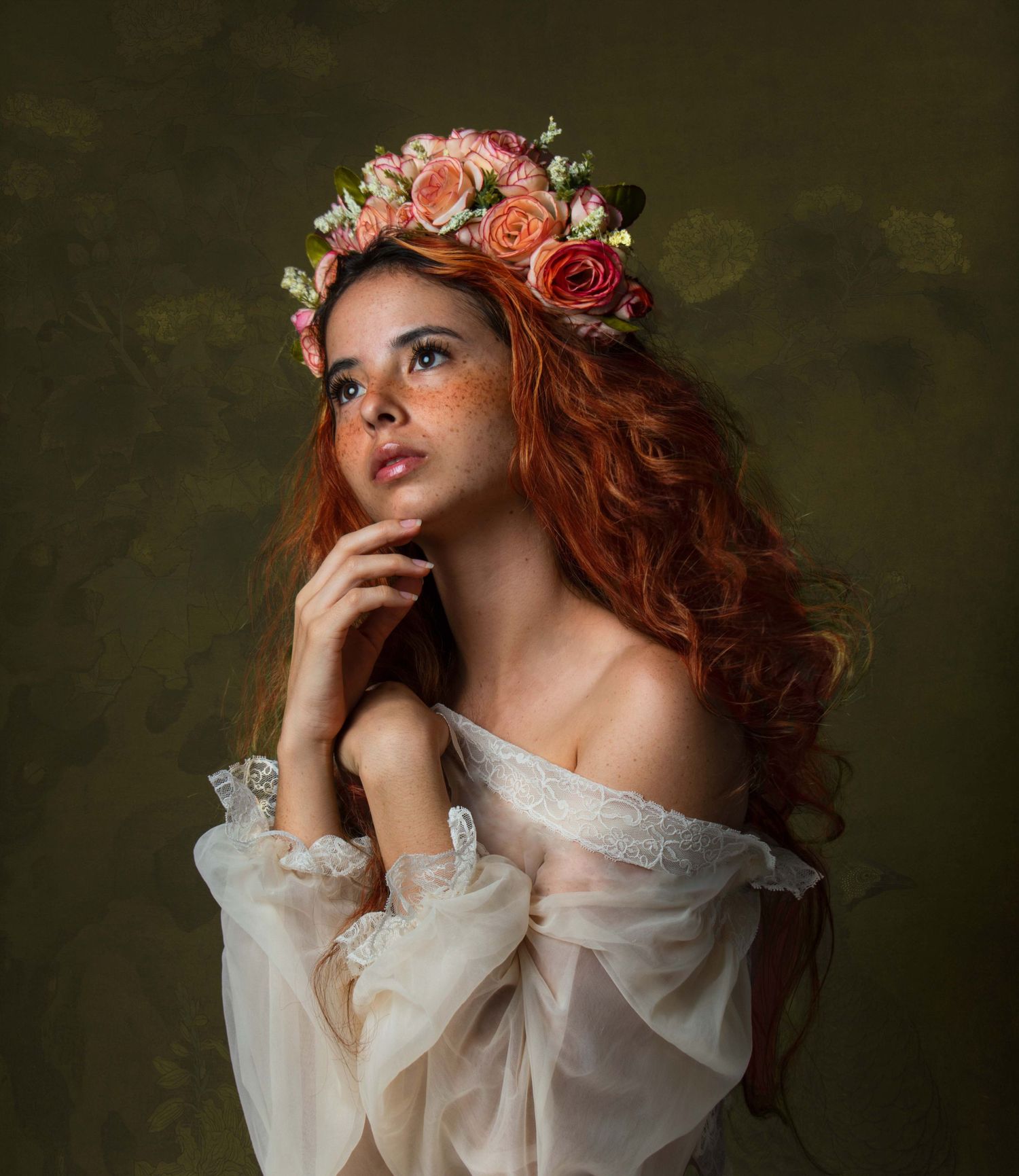 Portrait of a model wearing a floral crown and romantic off-shoulder dress against a dark background.