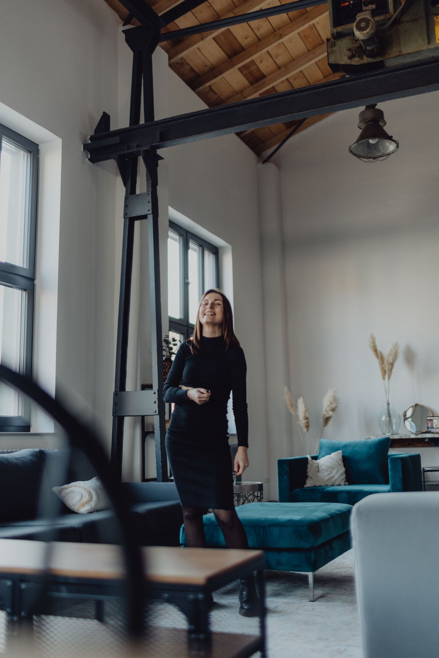Stylish interior of modern loft apartment with exposed beams and blue furniture.
