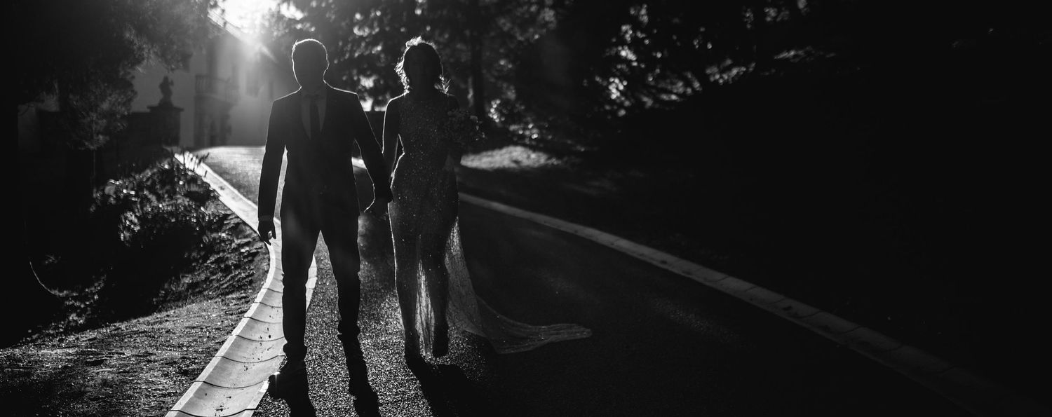 Silhouetted figures walking together on a path with dramatic backlighting from the sun.