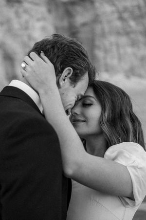 Intimate black and white portrait of a couple sharing a tender romantic moment during their wedding.