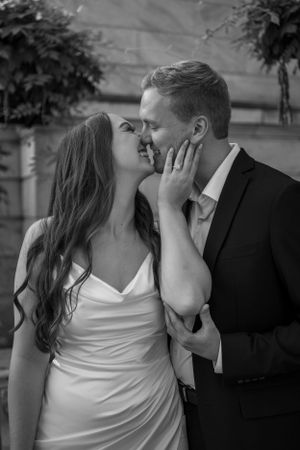 Romantic black and white portrait of couple sharing intimate moment outdoors.
