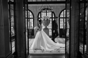 Silhouette of bride and groom framed by elegant arched doorway.