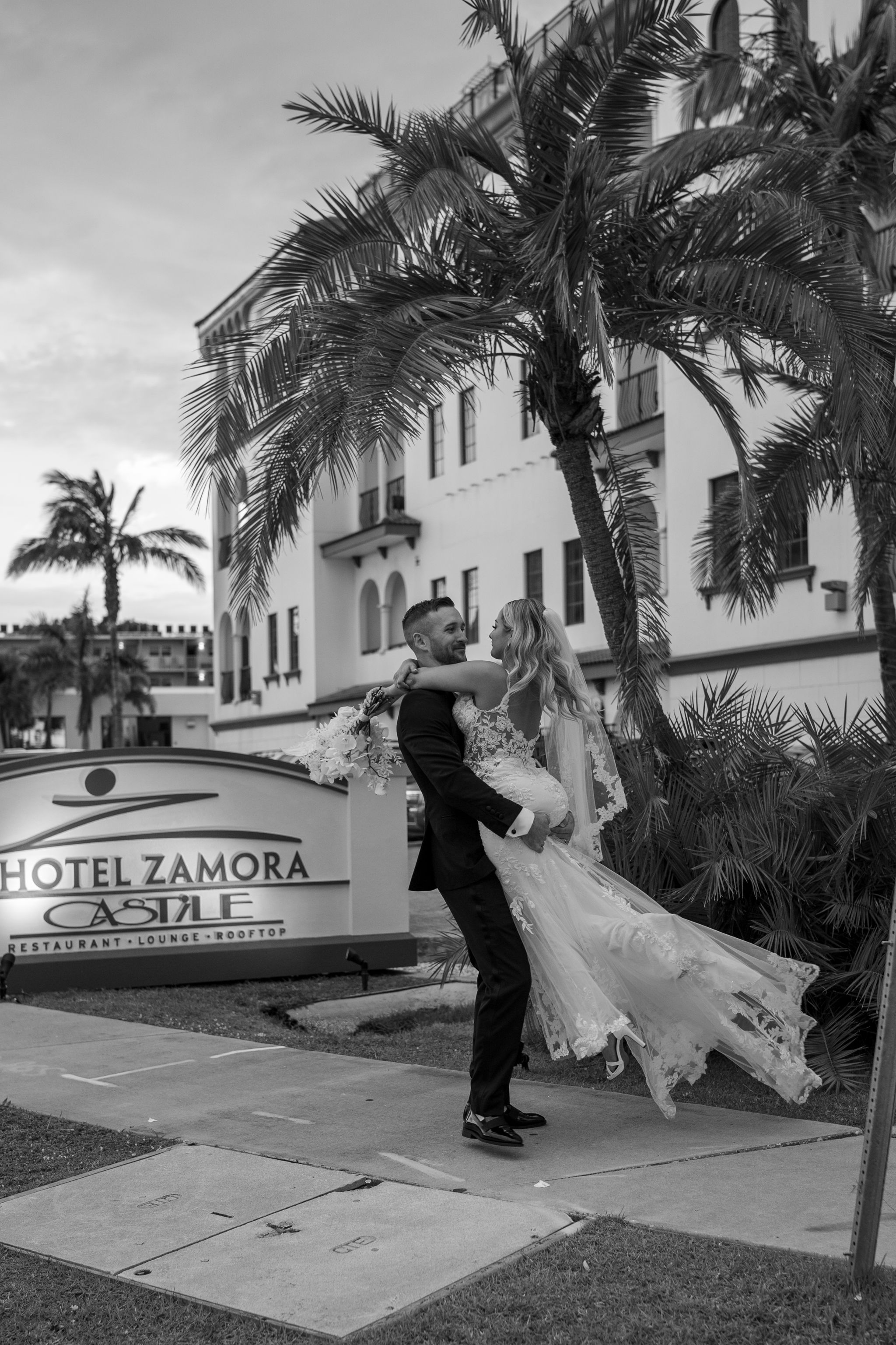 Black and white photo of a couple dancing in front of Hotel Zamora.