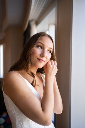 Elegant bridal portrait by window with soft natural lighting.