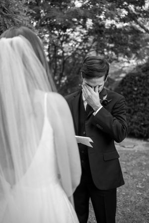 Emotional first look moment between couple during outdoor garden wedding ceremony.