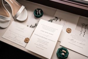 Wedding stationery suite with white invitations and green wax seals.