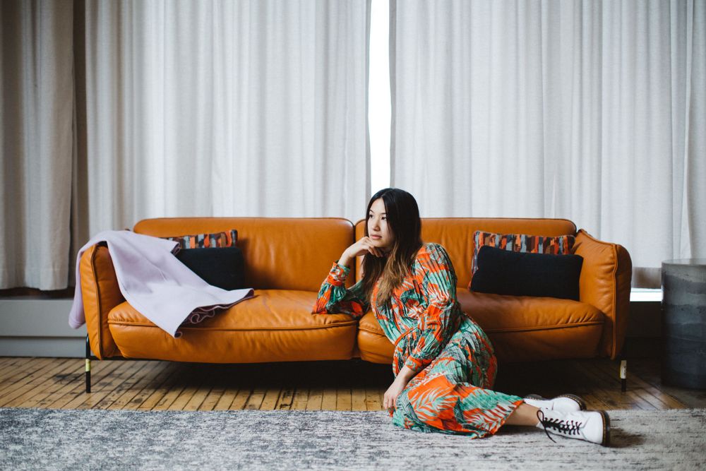 Relaxed indoor scene featuring orange leather couch and floral print clothing.