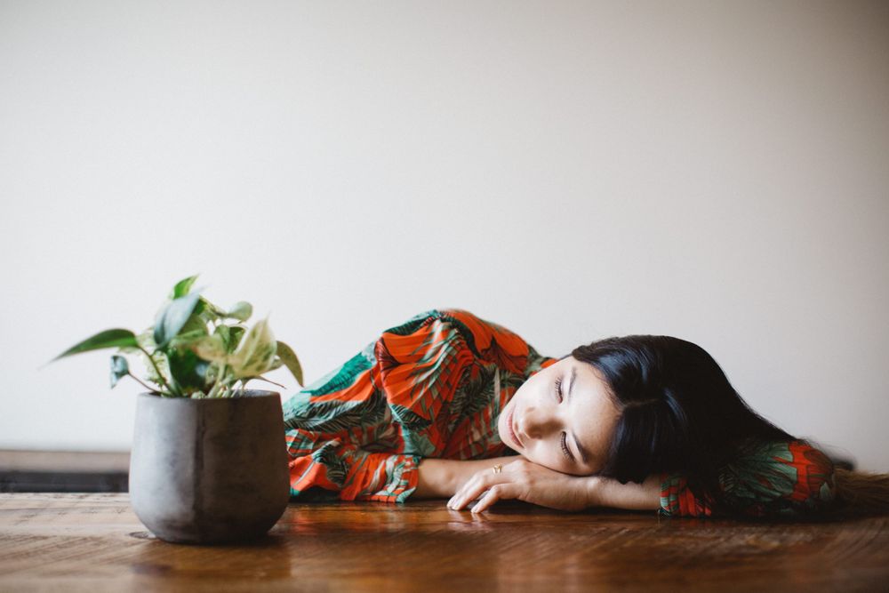 Artistic still life with floral dress and potted plant on wooden surface.