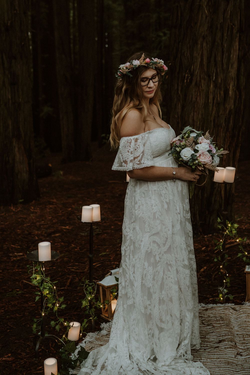 White lanterns and floral decorations accent a dreamy forest wedding scene.