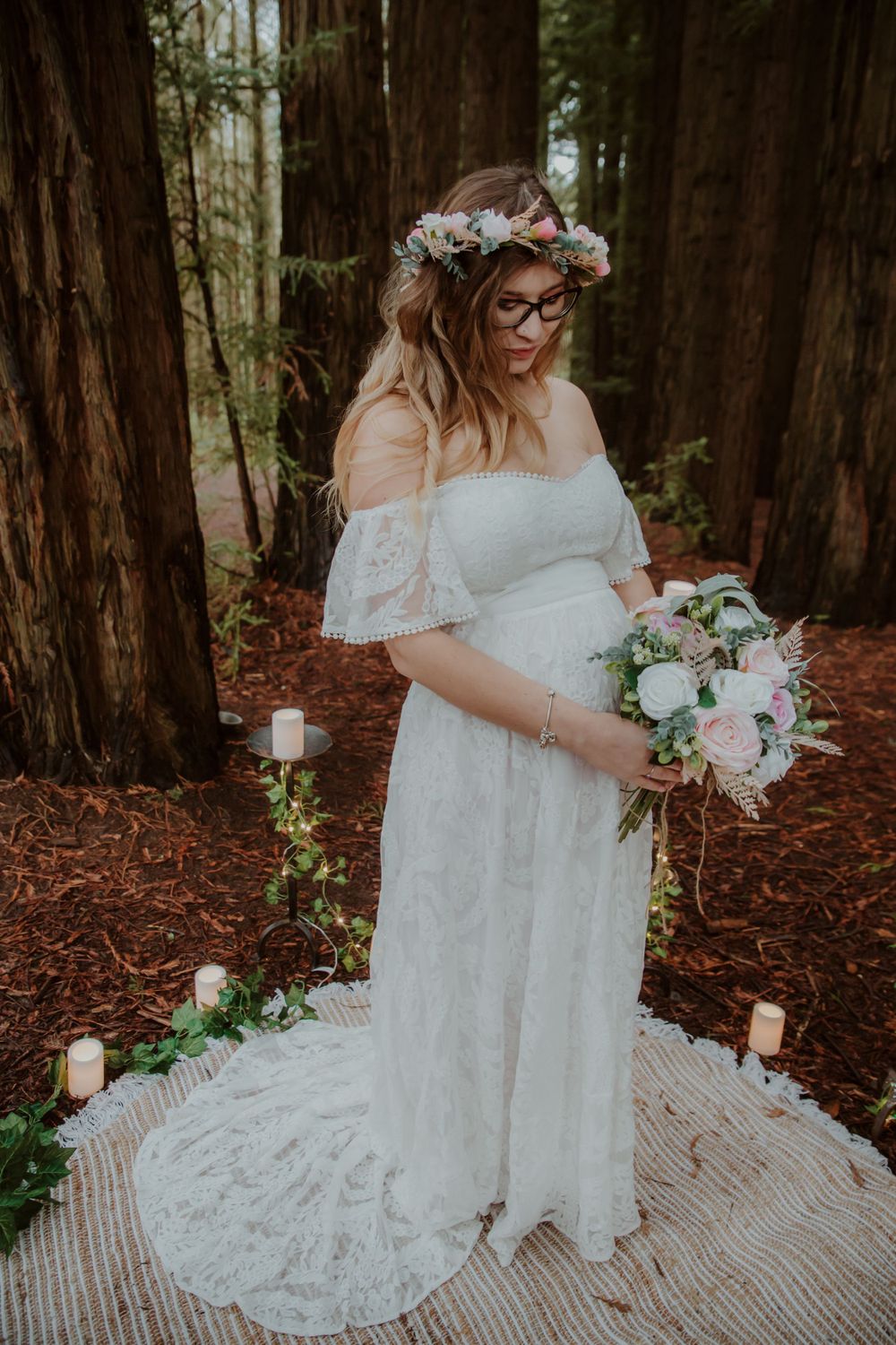An ethereal bridal scene features delicate lace and white florals in a redwood forest.