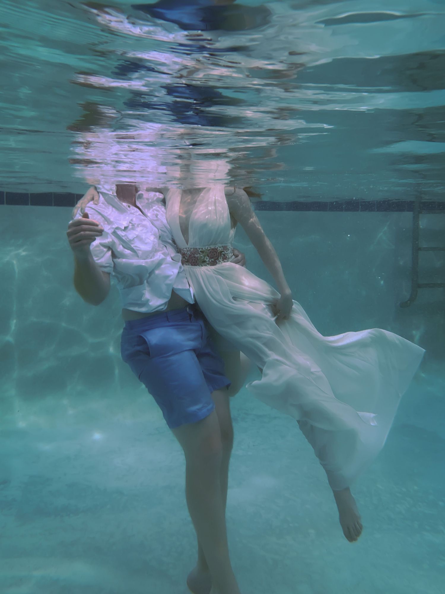 A man and a woman from the shoulders down under the water