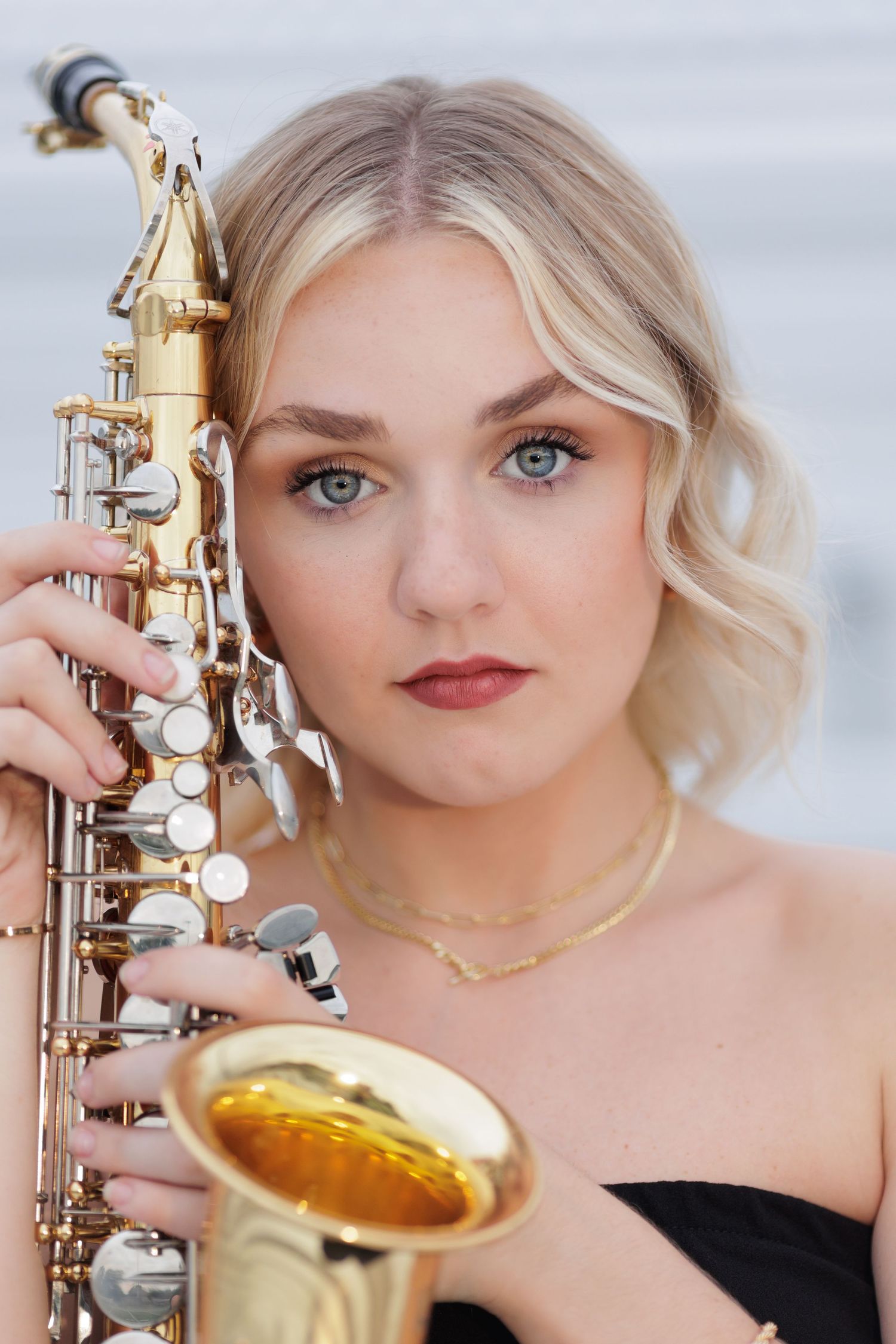 Close-up of high school senior band player and her saxophone.