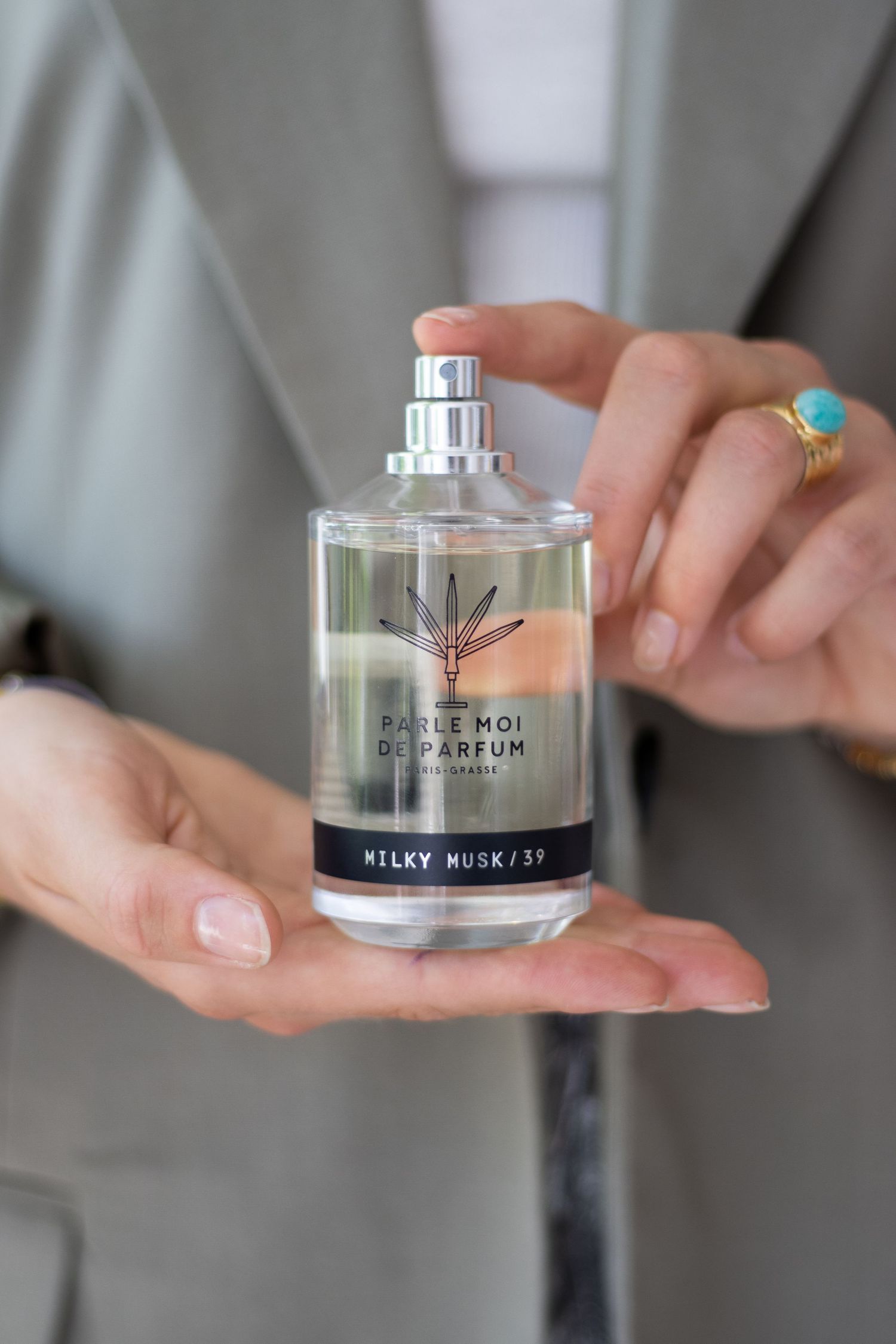 Stijlvol beeld van een hand die klaar is om parfum te sprayen.