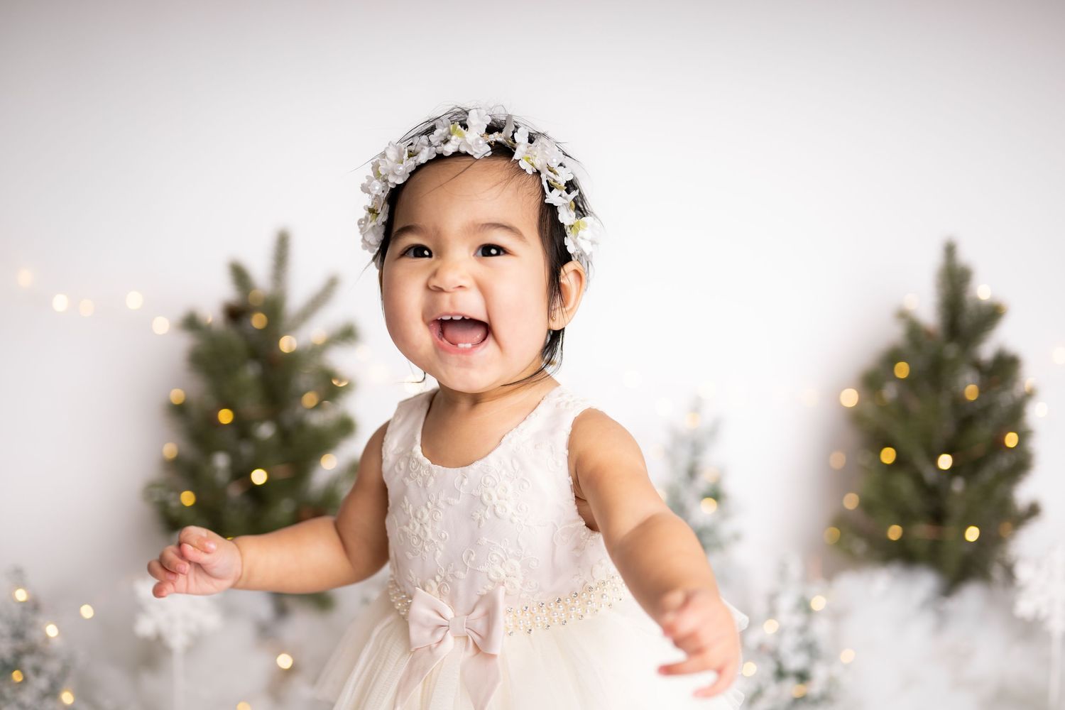 A joyful holiday portrait scene with decorated Christmas trees and twinkling fairy lights.