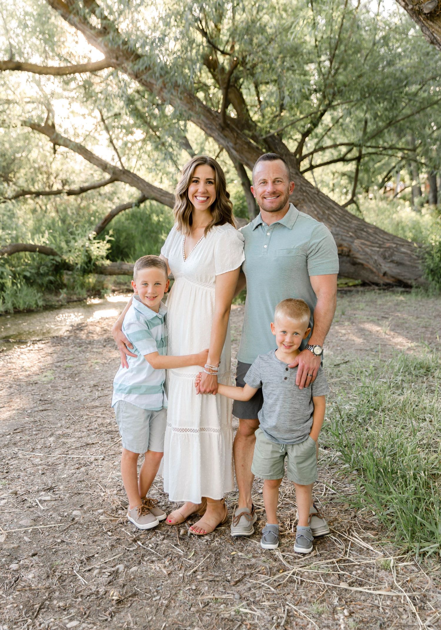 Jen holding bother her boys while Chris stands behind her with his arm around her for family pictures in Eagle Idaho.