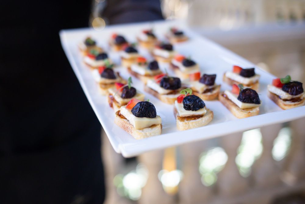 Elegant catering display of bite-sized hors d'oeuvres arranged on white serving platters.