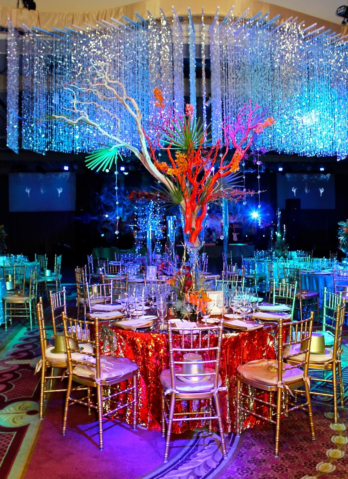 Dramatic event space with crystal hanging decorations and colorful LED lighting creating an ethereal atmosphere.