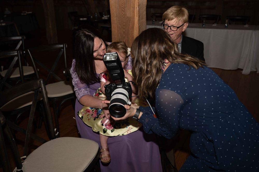 Photographers with professional cameras gather around to take pictures at an event.