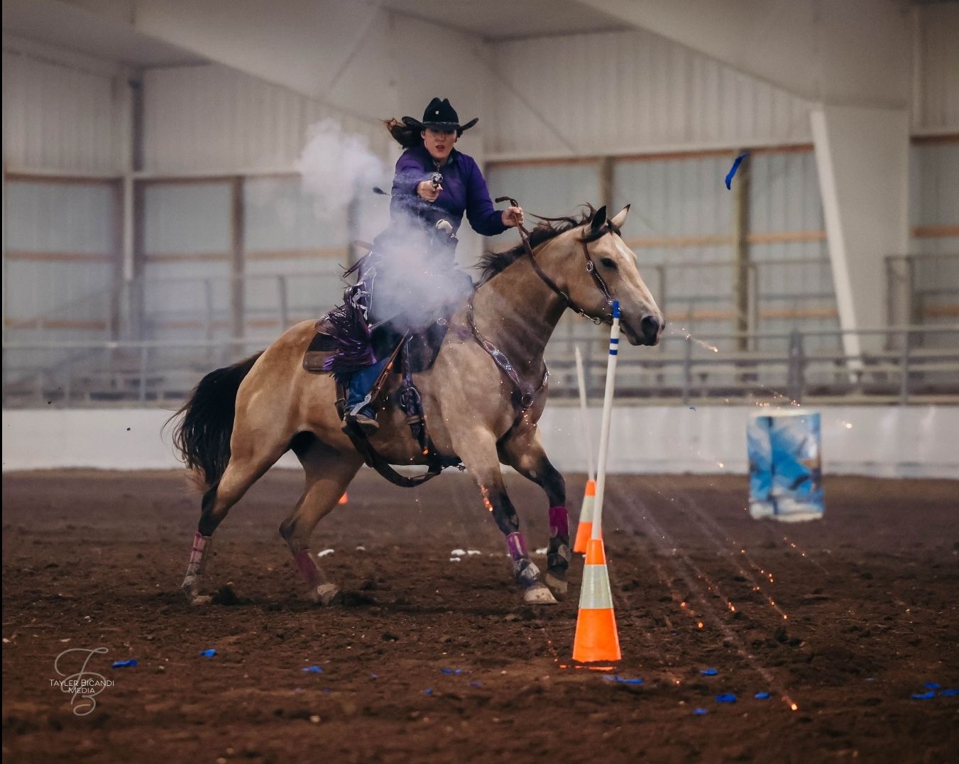 A cowgirl shoots a balloon in a blaze of sparks during her closed-course Cowboy Mounted Shooting competition in Missouri.